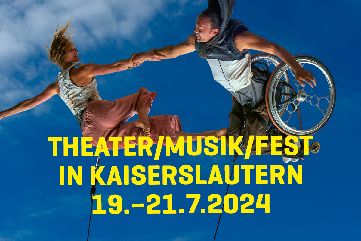 Farbfoto. Zwei Personen vor einem blauen Himmel mit Wolken. Sie hängen an Seilen und halten sich in einer akrobatischen Pose an den Armen. Das Bild steht kopfüber, die Seile kommen von unten. Eine Person sitzt in einem Rollstuhl. Auf dem Bild steht in gel